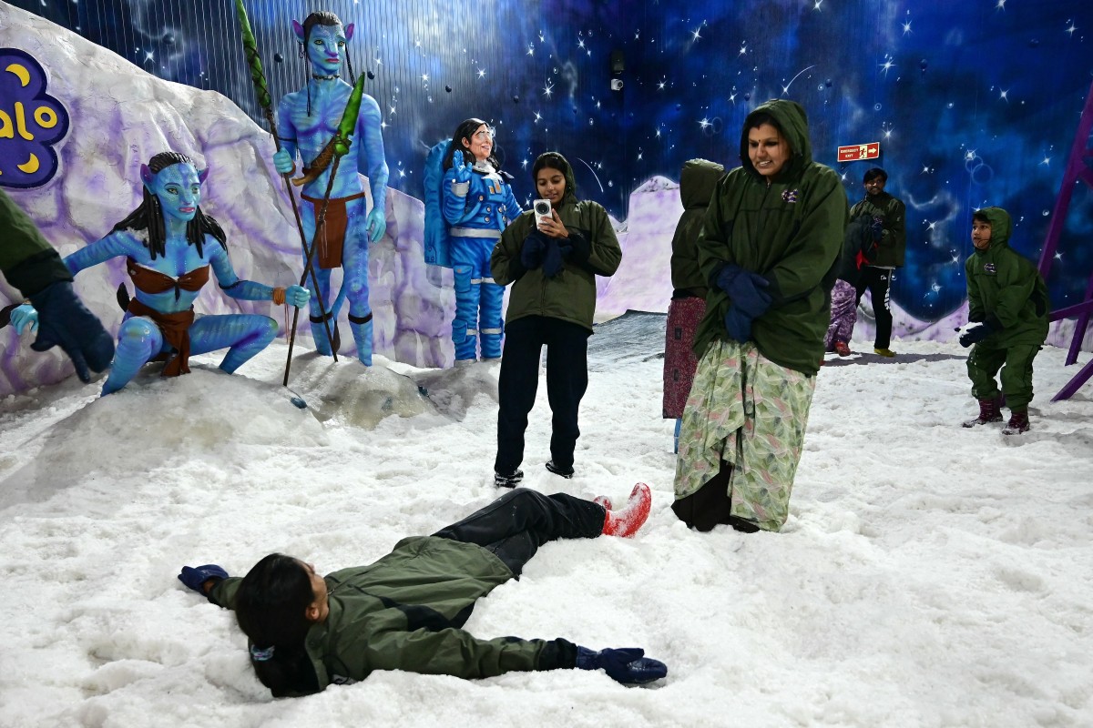يلتقط الزائرون صوراً وسط الثلوج الاصطناعية في Iceberg Snow World