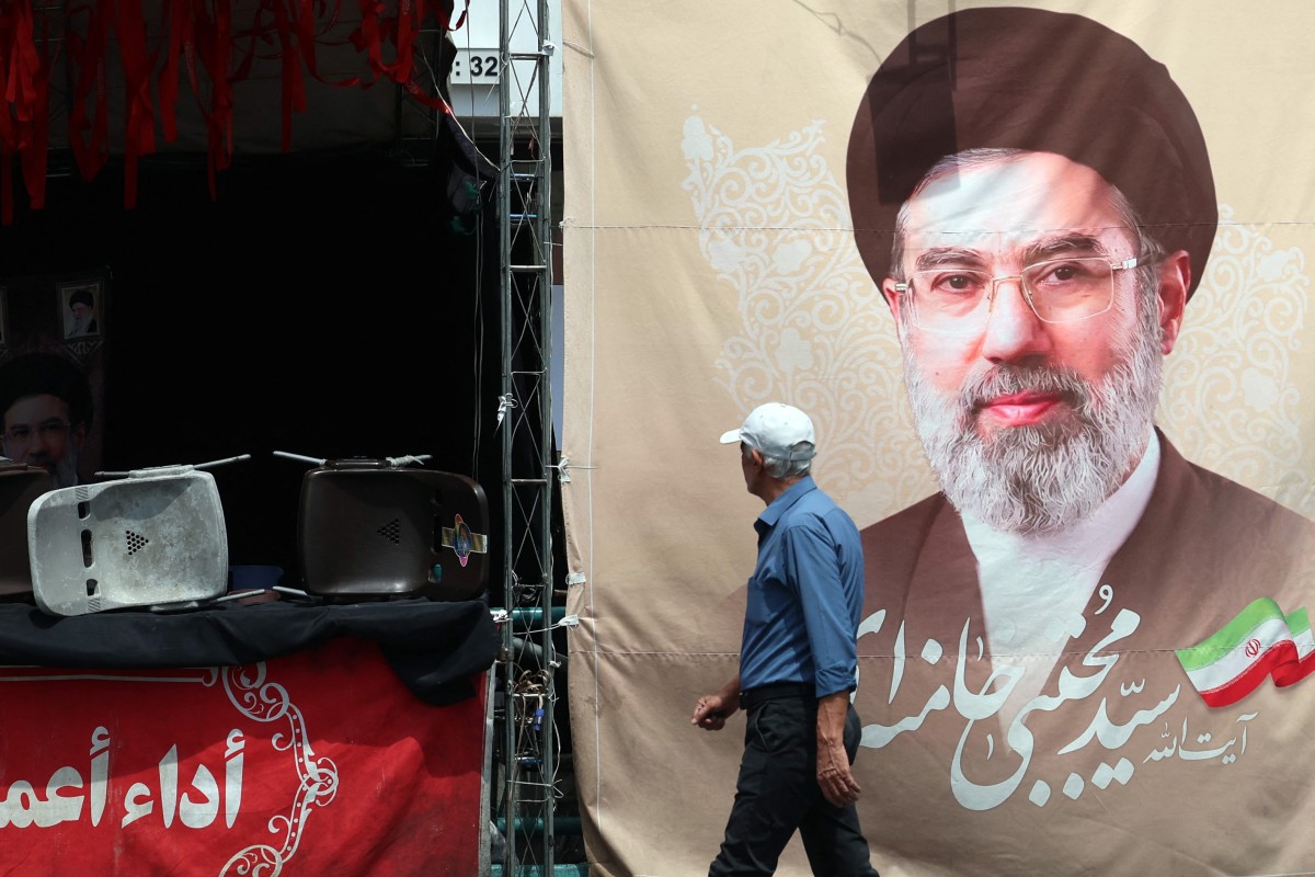 إيراني يمر أمام لوحة تحمل صورة المرشد الأعلى مجتبى خامنئي، في أحد شوارع طهران، (ا ف ب).