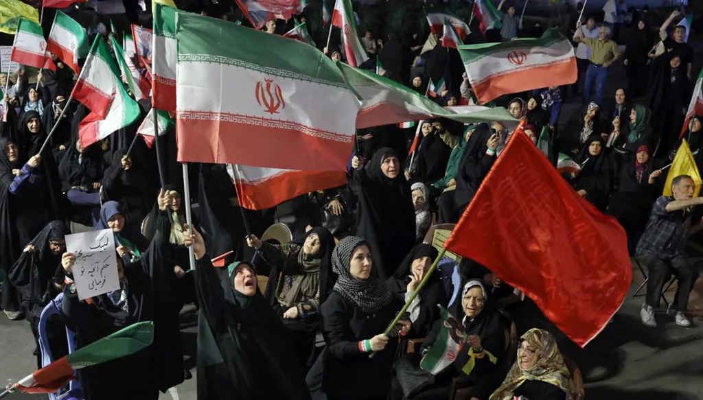 مناصرون للنظام يرفعون العلم الإيراني في طهران (أ ف ب).