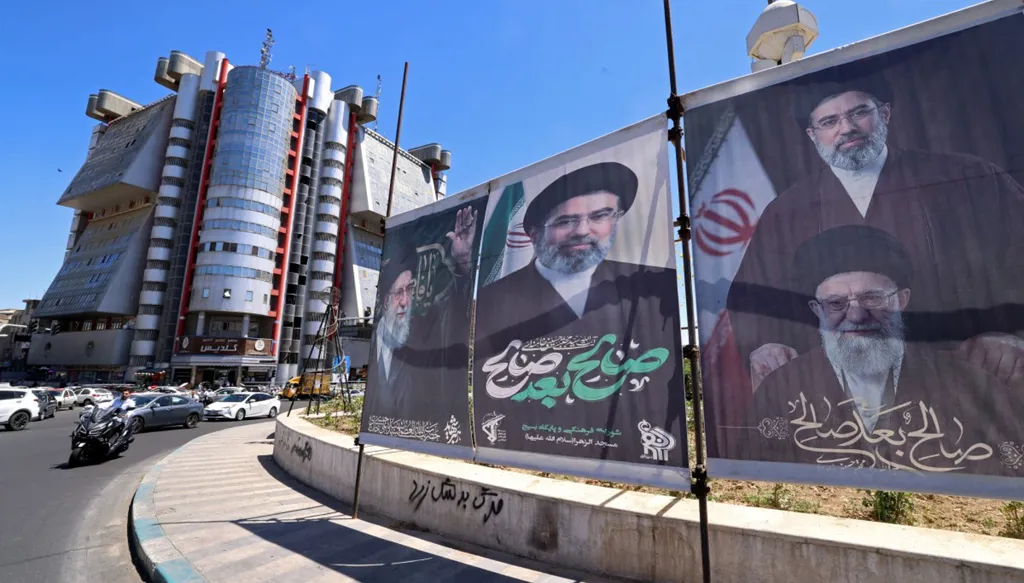 صور للمرشد الإيراني مجتبى امنئي ووالجه الراحل علي خامنئي في طهران (أ ف ب).
