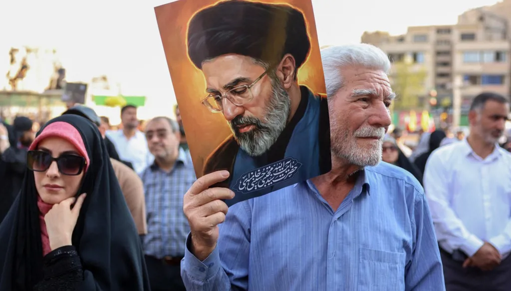 شخص يرفع صورة مجبتى خامنئي في طهران (أ ف ب).