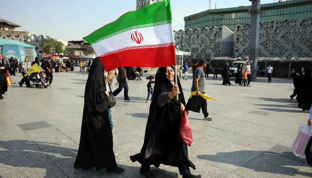إيرانيات يرفعنَ علم بلادهنَّ في طهران (أ ف ب).