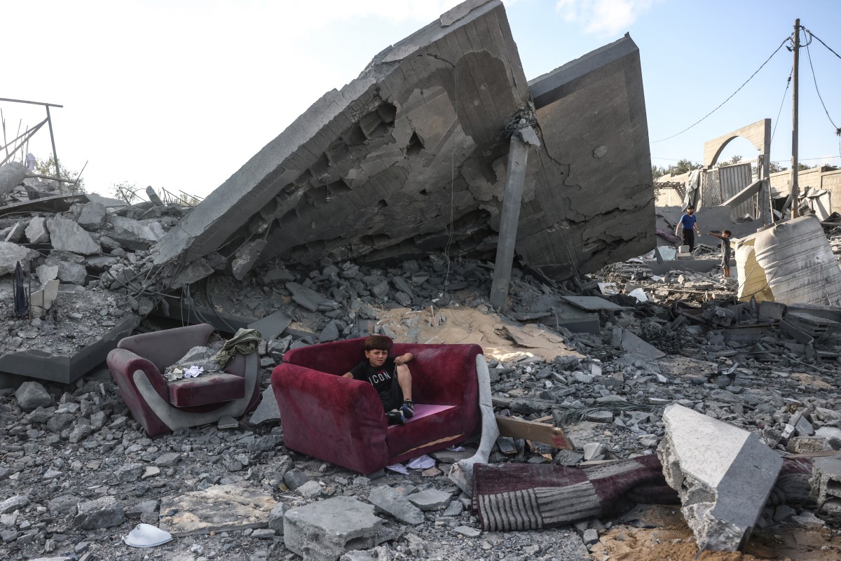 طفل يجلس وسط الركام في غزة (أ ف ب)