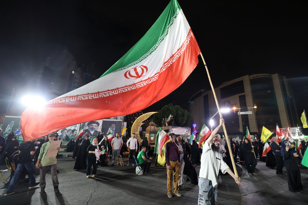 منصرون للنظام الإيران يرفعون علم بلادهم في طهران (أ ف ب).