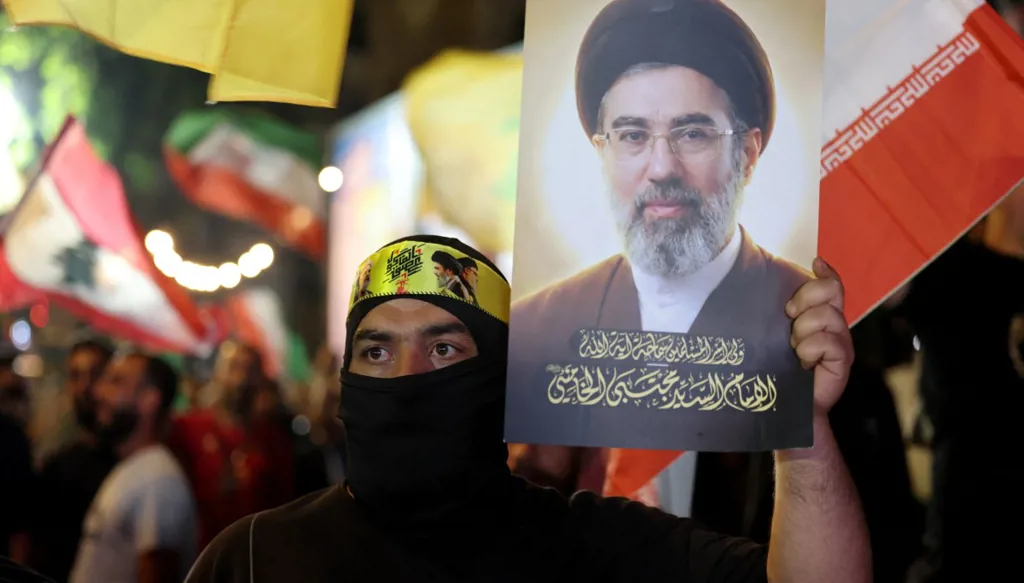 أحد أنصار "حزب الله" يحمل صورة للمرشد الأعلى الإيراني مجتبى خامنئي خلال مظاهرة مناهضة للولايات المتحدة وإسرائيل في ضواحي بيروت الجنوبية (أ ف ب)