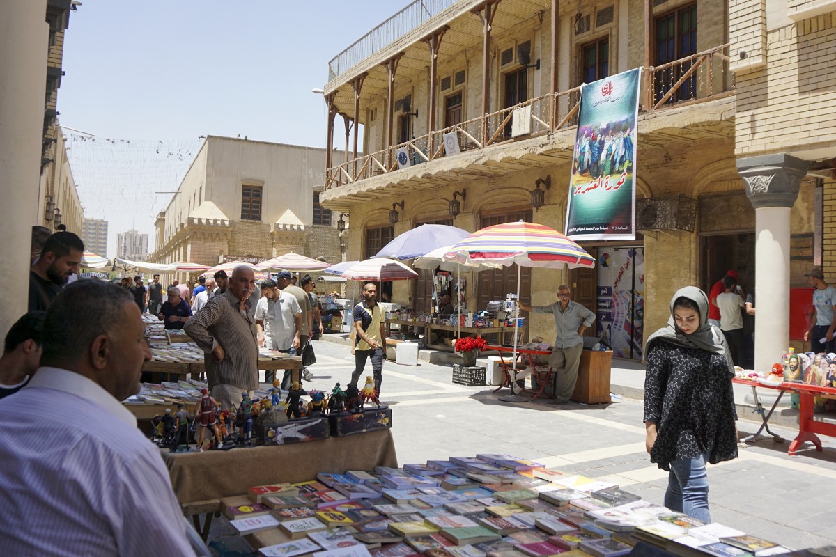 عراقيون يتسوقون في سوق الكتب الشهير بشارع المتنبي في بغداد. (أ ف ب)