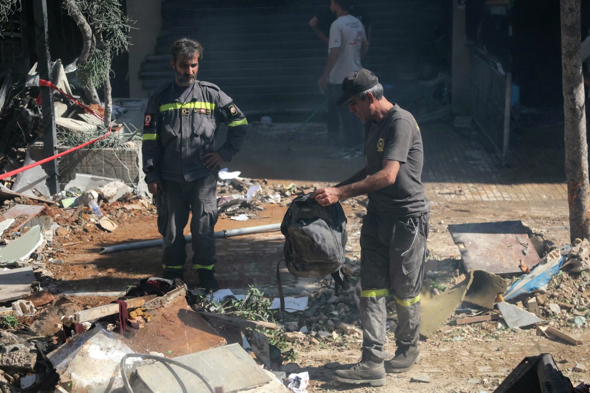 إزالة الأنقاض في موقع غارة جوية إسرائيلية استهدفت مبنى في الضواحي الجنوبية لبيروت (أ ف ب)