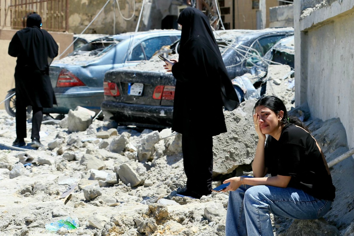 يقوم أفراد فرق الطوارئ والمدنيون اللبنانيون بتفتيش موقع غارة جوية إسرائيلية استهدفت قرية قناريت في جنوب لبنان (أ ف ب)