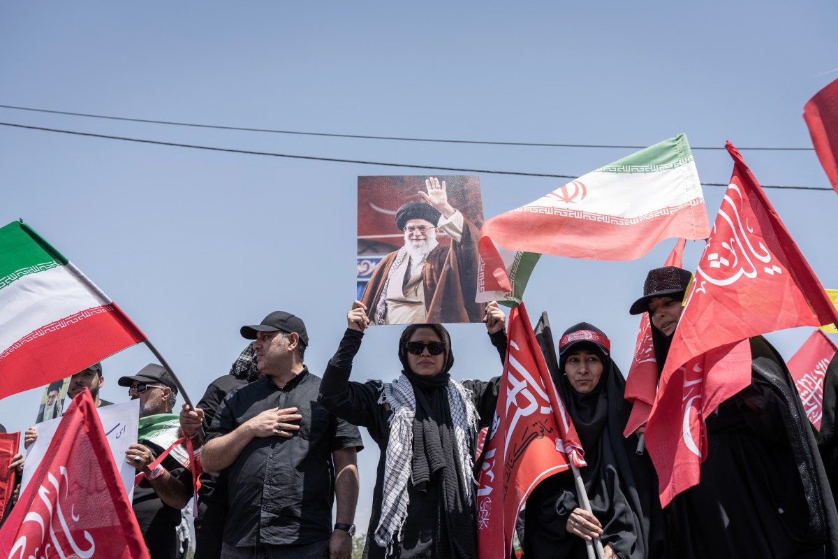 إيرانية تحمل صورة خامنئي. (أ ف ب)