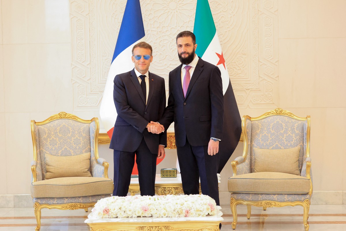 الرئيس الفرنسي إيمانويل ماكرون (يسار الصورة) يصافح الرئيس السوري أحمد الشرع قبيل لقائهما في قصر الشعب بدمشق في 7 تموز/يوليو 2026 (أ ف ب)
