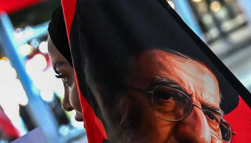 امرأة تحمل صورة علي خامنئي (أ ف ب).