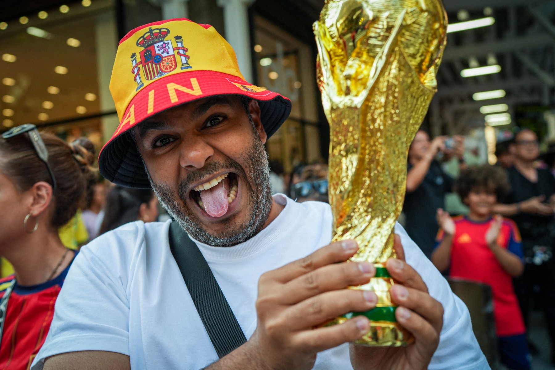 أحد المشجعين في كأس العالم 2026 يرفع مجسم لكأس العالم.