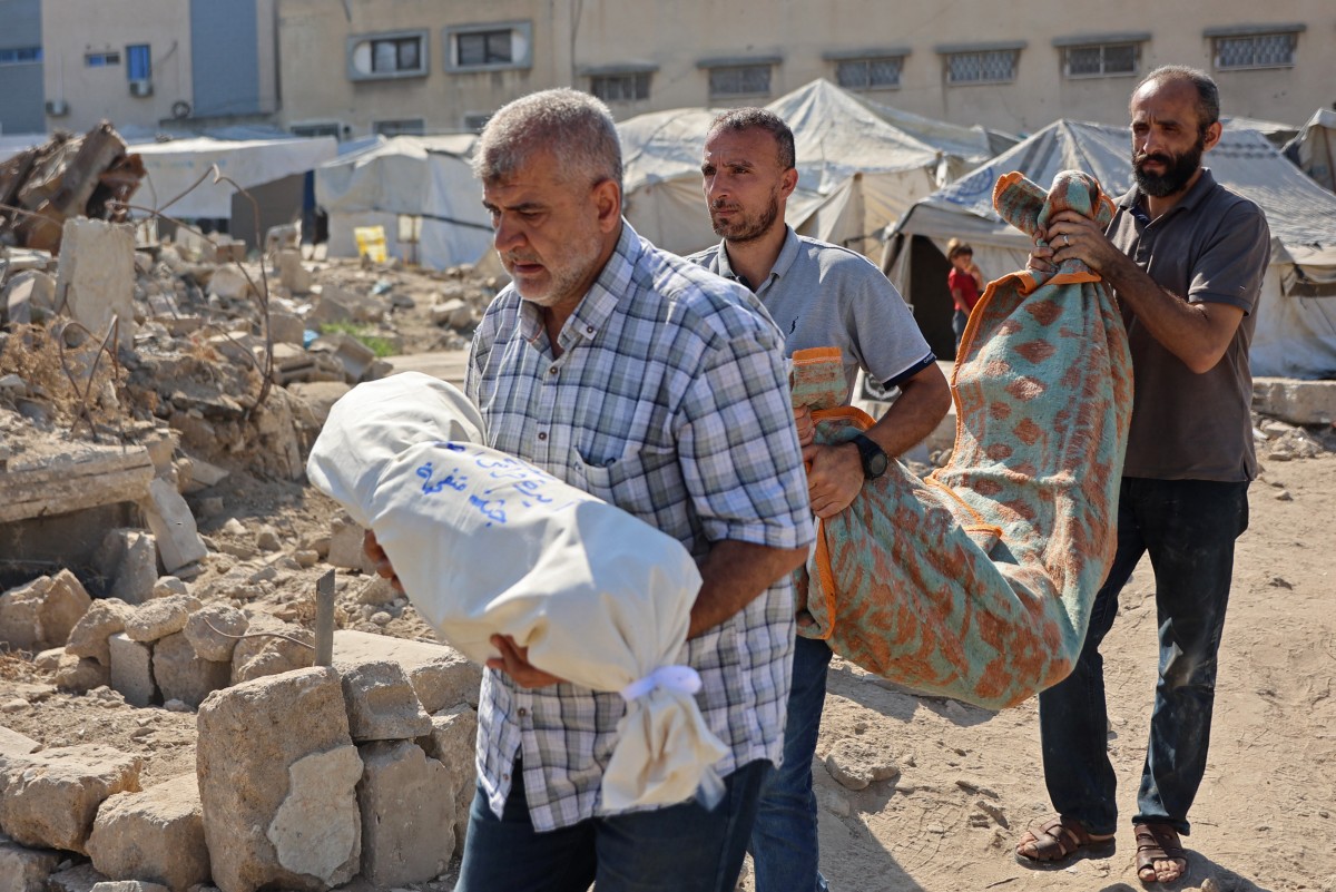 أفراد عائلات يحملون جثامين فلسطينيين لقوا حتفهم بعد غارة جوية إسرائيلية في غزة، (ا ف ب).