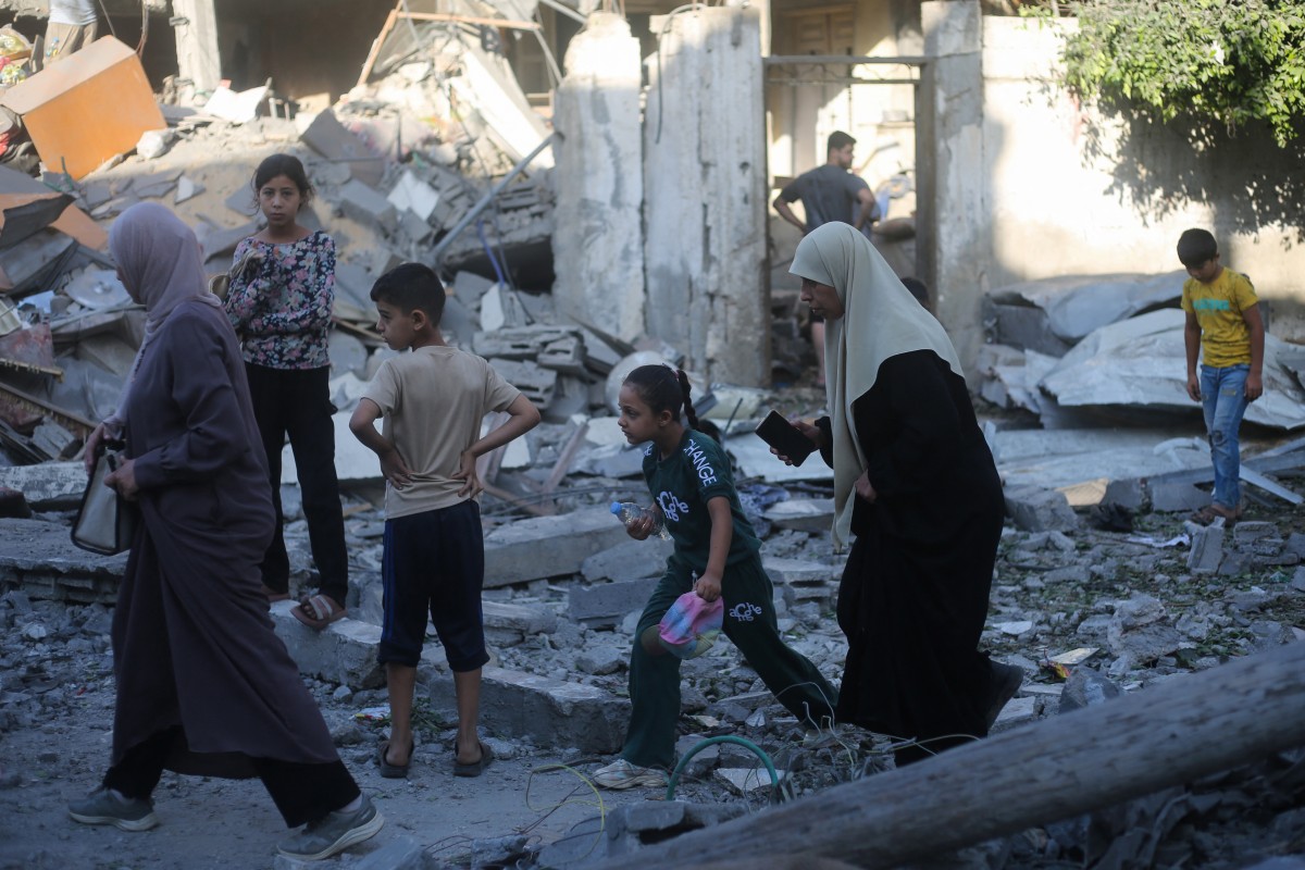 فلسطينيون يتفقدون مباني متضررة ومدمرة بعد استهدافها بضربات إسرائيلية