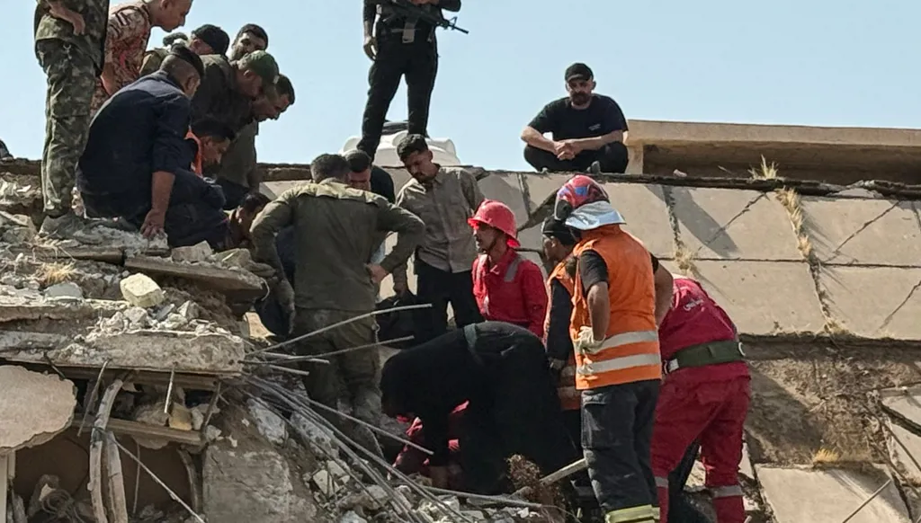 عناصر أمن وإسعاف في موقع غارات أميركية وسعودية استهدفت قاعدة لـ"الحشد الشعبي" في محافظة ديالى. (أ ف ب)