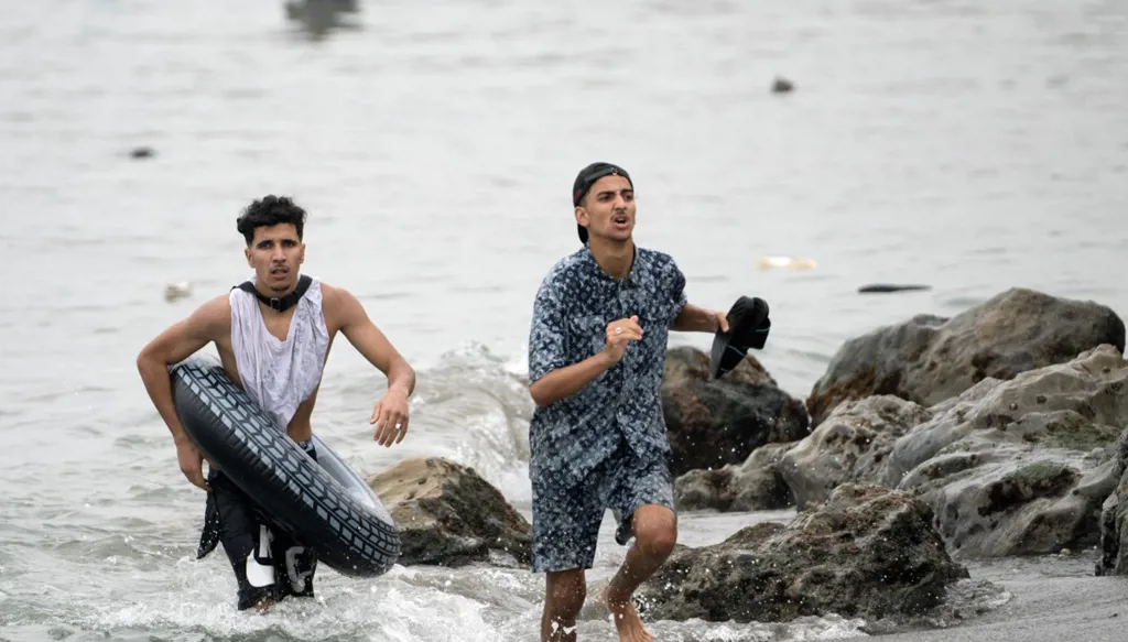 يسبح المهاجرون عبر المياه القريبة من الحدود مع المغرب لدخول جيب سبتة (أ ف ب). 
