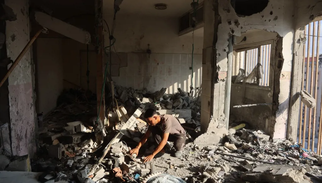 فلسطينيون ينقذون ما يمكن إنقاذه من منزل سكني استُهدف بغارات جوية إسرائيلية ليلية في مدينة غزة (أ ف ب)