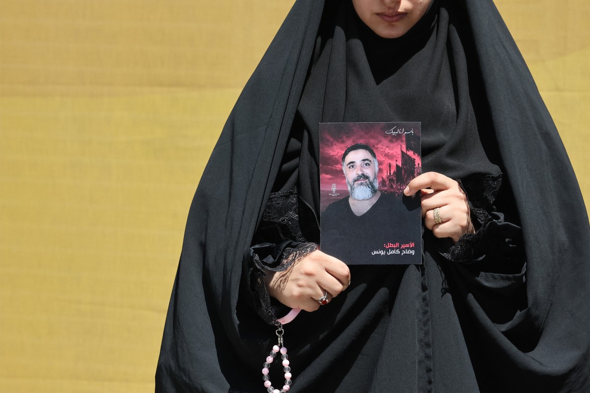 (أ. ب) ابتسام حسين تحمل صورة زوجها الأسير وضاح يونس