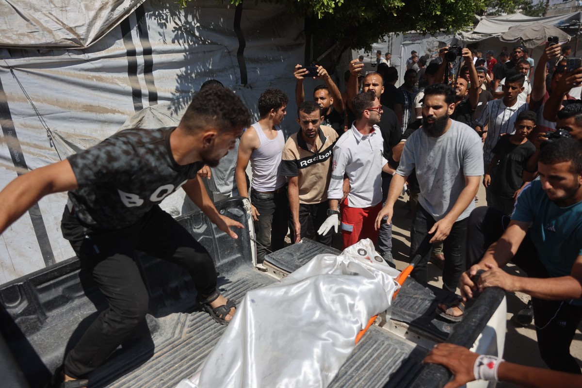 فلسطينيون نازحون ينقلون جثمان ضحية بعيداً عن موقع غارة إسرائيلية استهدفت مقر شرطة البلدية في مدينة غزة. (أ ف ب)