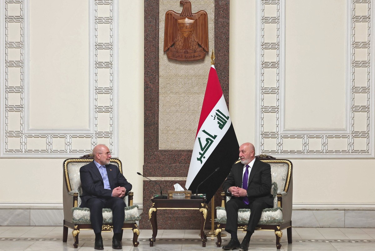 رئيس البرلمان الإيراني محمد باقر قاليباف وهو يتحدث مع الرئيس العراقي نزار العميدي خلال اجتماعهما في قصر السلام ببغداد. (أ ف ب)