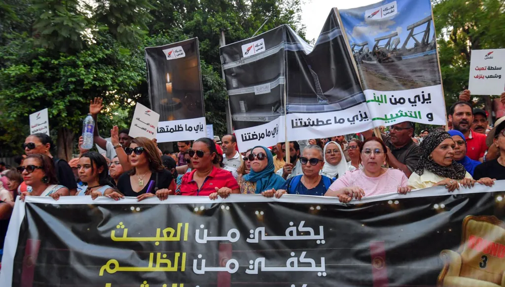 متظاهرون يرفعون لافتة حراك "نَفَس"، وهو تجمع سياسي معارض واسع، خلال مسيرة احتجاجية ضد الرئيس التونسي قيس سعيّد في العاصمة تونس، 20 آب/أغسطس 2026. (أ ف ب)
