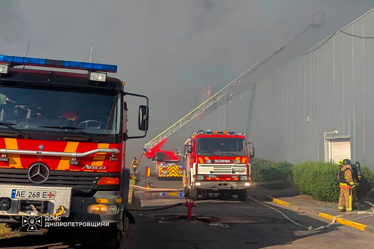 رجال إطفاء يعملون على إخماد حريق اندلع في مركز تجاري بمدينة كريفي ريغ إثر ضربة روسية. (أ ف ب)