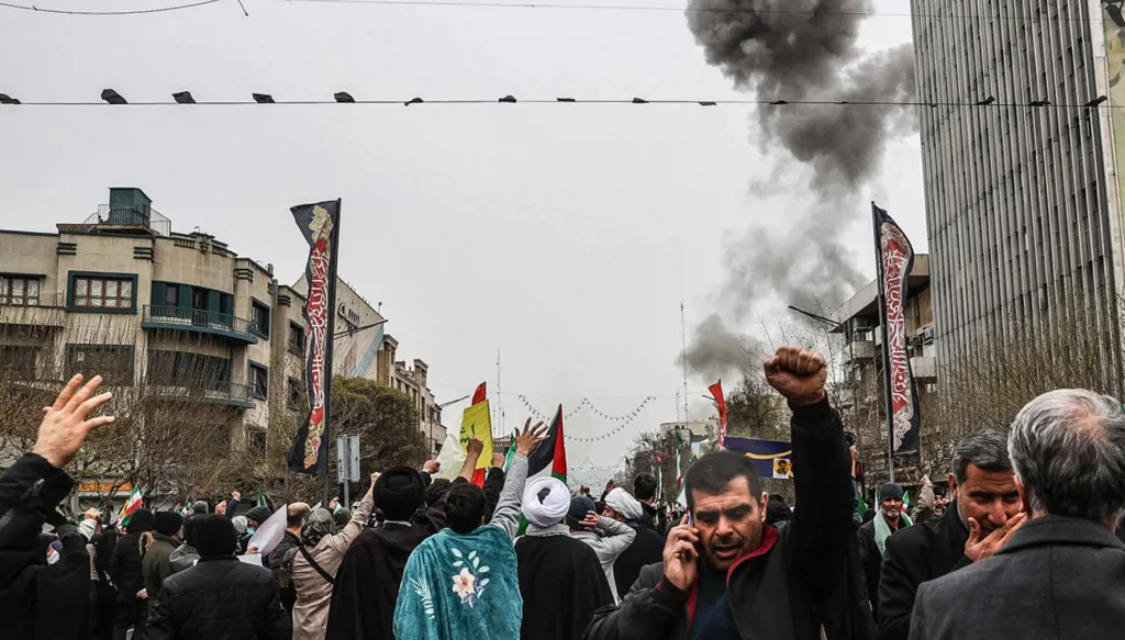 دخان أسود يتصاعد عقب غارة جوية، فيما يشارك إيرانيون في مسيرة "يوم القدس" دعماً للشعب الفلسطيني في طهران في 13 آذار/مارس 2026. (أ ف ب)
