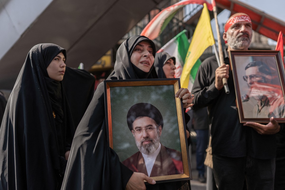 سيّدة ترفع صورة المرشد الإيراني آية الله مجتبى خامنئي، خلال مراسم تشييع المرشد الراحل آية الله علي خامنئي وأفراد من عائلته في طهران في 6 تموز/يوليو 2026. (أ ف ب)