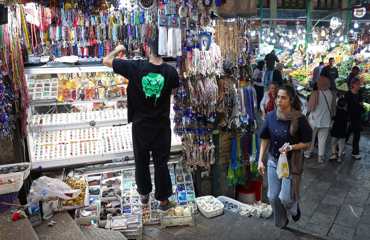 متسوقون يشترون الخضر والفاكهة في سوق تجريش التاريخية شمال طهران في 25 آب/أغسطس 2026. (أ ف ب)