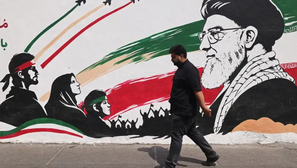 رجل يمرّ بجانب جدارية للمرشد الإيراني الراحل علي خامنئي، في أحد شوارع وسط طهران في 31 آب 2026 (أ ف ب).