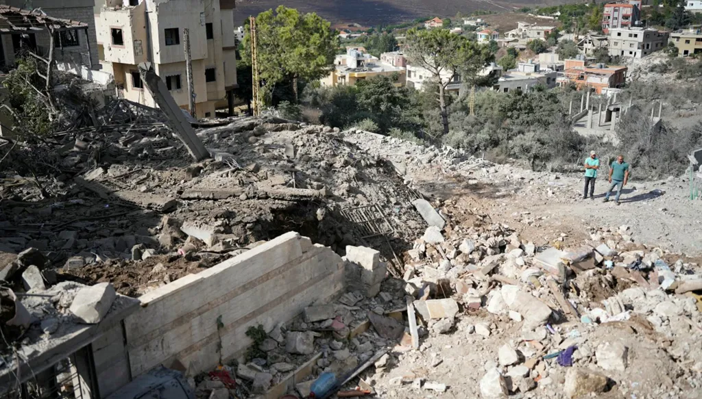 سكان يتفقّدون الدمار غداة غارة إسرائيلية استهدفت بلدة ميفدون جنوبي لبنان (أ ف ب)