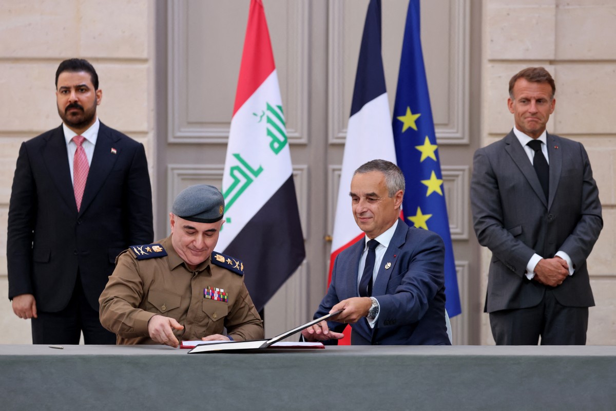 مسؤولان فرنسي وعراقي يوقعان اتفاقاً في حضور الرئيس الفرنسي إيمانويل ماكرون ورئيس الوزراء العراقي علي الزيدي في قصر الإليزيه بباريس، 14 أيلول/سبتمبر 2026. (أ ف ب)