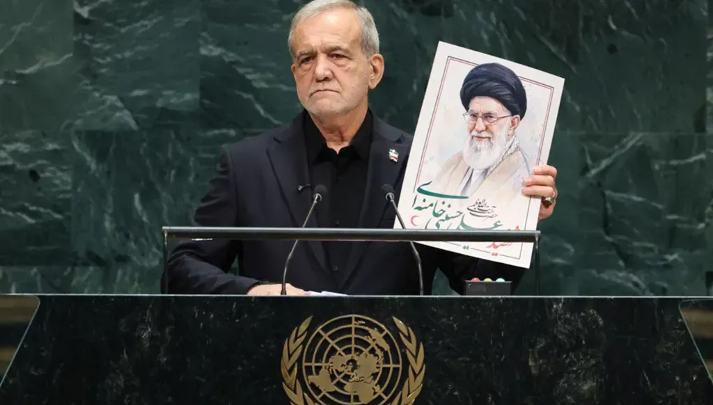 الرئيس الإيراني مسعود بزشكيان يتحدث حاملاً صورة المرشد الأعلى السابق لإيران، خلال أعمال الدورة الـ81 للجمعية العامة للأمم المتحدة (أ ف ب).