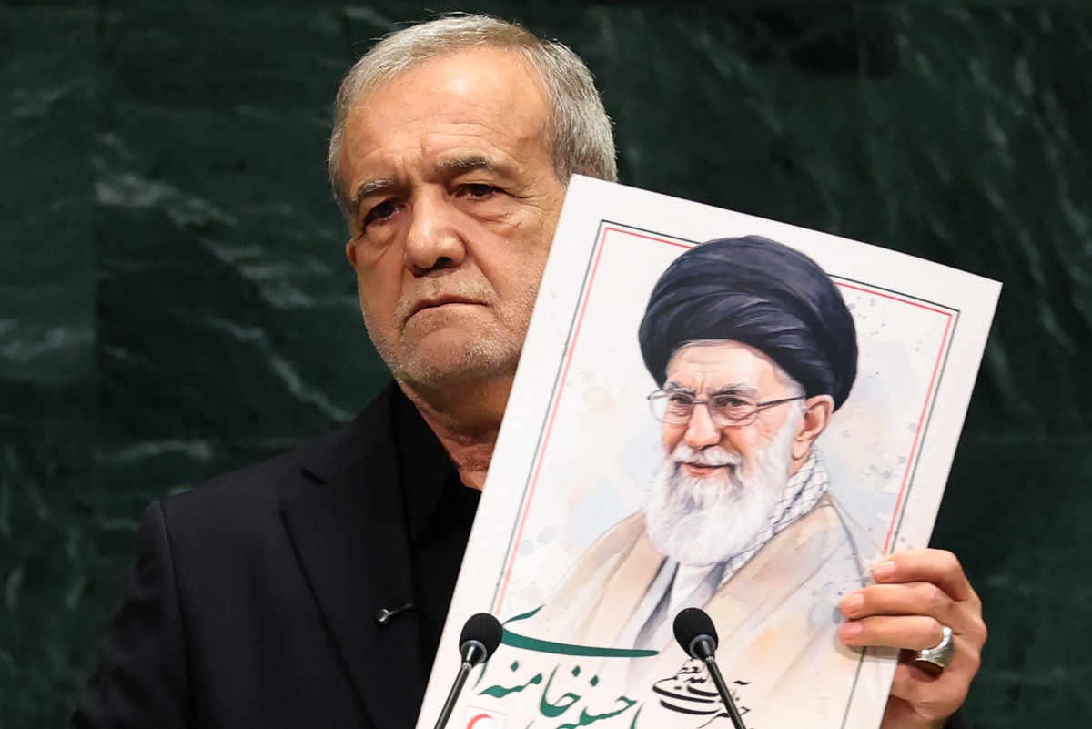 الرئيس الإيراني مسعود بيزشكيان يتحدث وهو يحمل صورة لعلي خامنئي، المرشد الأعلى السابق لإيران، خلال الدورة الحادية والثمانين للجمعية العامة للأمم المتحدة (أ ف ب).
