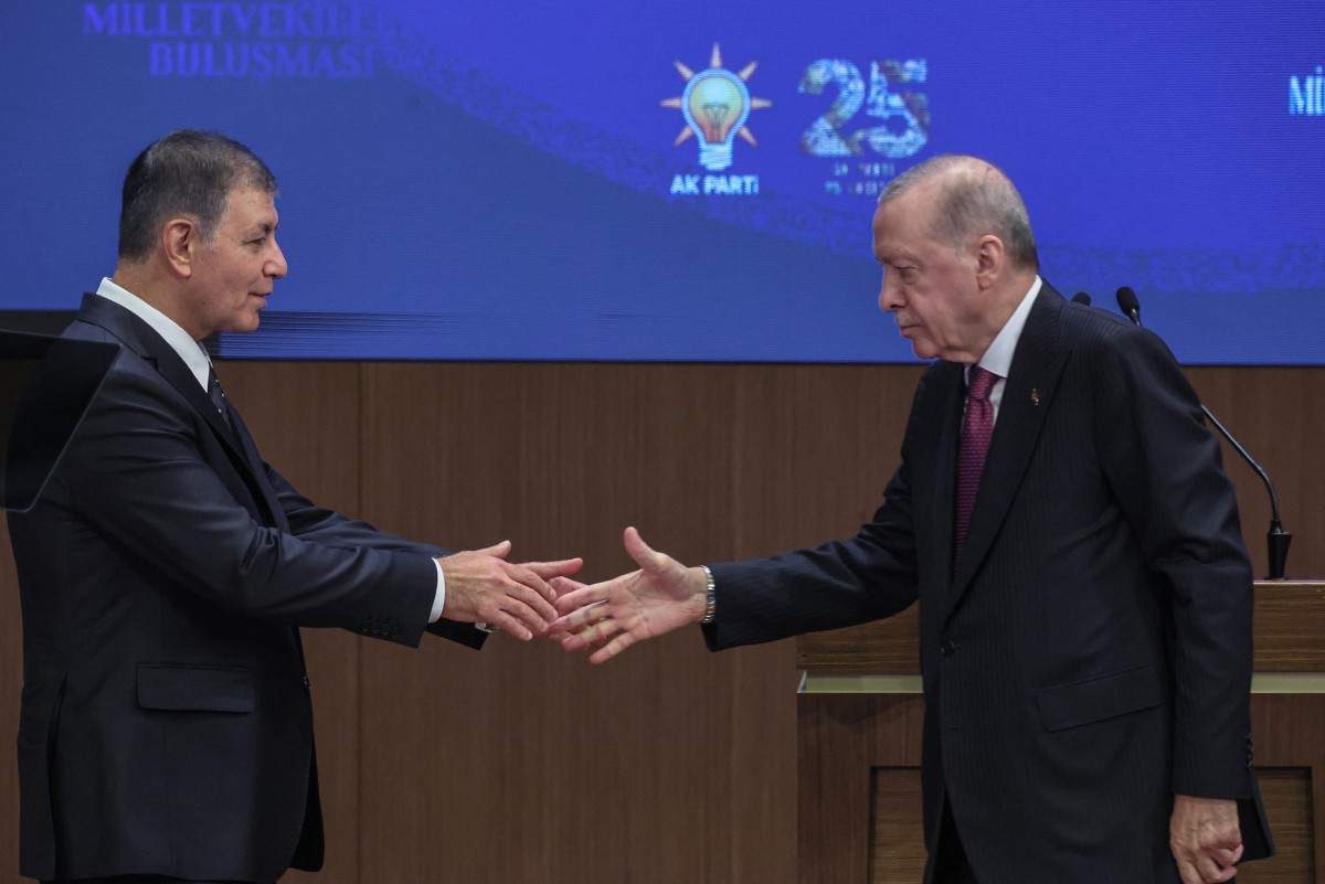 صافح رئيس بلدية إزمير جميل توغاي (يسار) الرئيس التركي رجب طيب أردوغان (يمين) بعد انضمامه إلى حزب العدالة والتنمية الحاكم خلال اجتماع مع نواب الحزب في أنقرة، في 7 تشرين الأول/أكتوبر 2026. (أ ف ب )