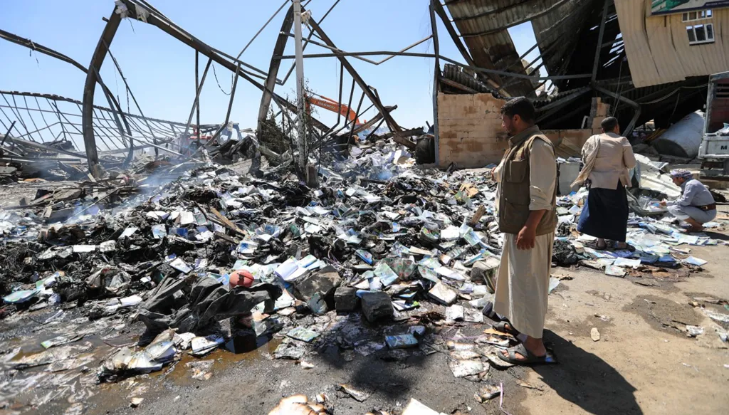 يمنيون يتفقدون الأضرار في مصنع للإسفنج بحي الروضة في صنعاء، عقب غارة جوية نُسبت إلى السعودية، 9 تشرين الأول/أكتوبر 2026. (أ ف ب)