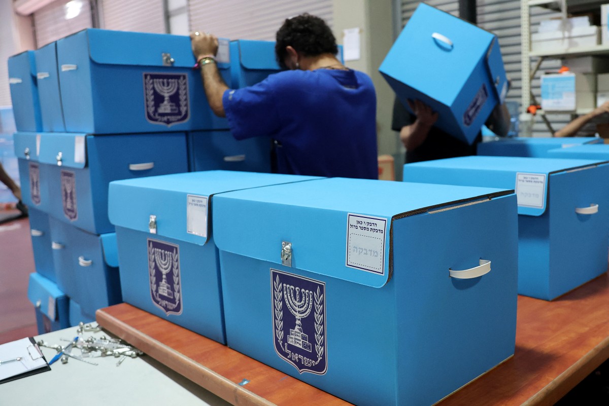 موظف في لجنة الانتخابات الإسرائيلية يرتّب صناديق الاقتراع (أ ف ب)