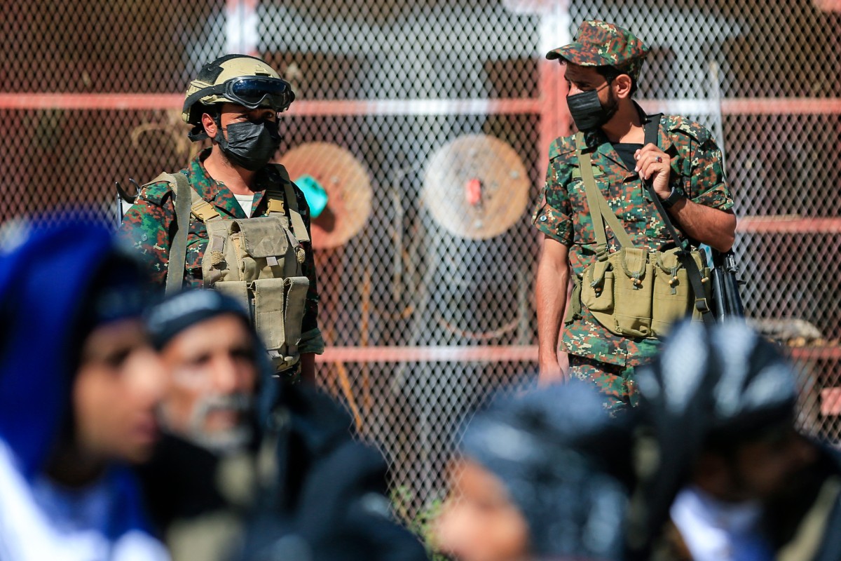 عناصر أمن حوثيون يرافقون سجناء أُفرج عنهم، أثناء انتظارهم لقاء ذويهم في العاصمة اليمنية صنعاء الخاضعة لسيطرة الحوثيين، السبت 17 تشرين الأول/أكتوبر 2026. (أ ف ب)