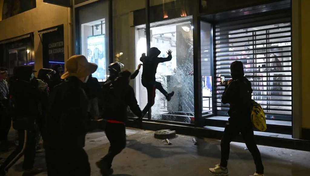 أشخاص يحاولون تحطيم واجهة متجر (سنايبس) (Snipes) بالقرب من (شاتليه - ليه هال) (Chatelet - Les Halles)، في وسط باريس، في 18 تشرين الأول/أكتوبر 2026. (أ ف ب)