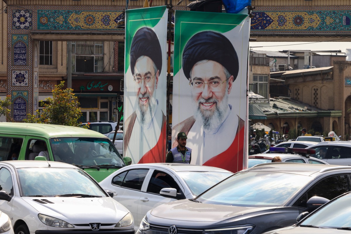 صورتان متجانبتان للمرشد الإيراني الأعلى مجتبى خامنئي في أحد شوارع طهران. (أ ف ب)