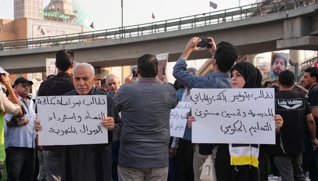 متظاهرون يرفعون لافتات خلال إحياء الذكرى السابعة لاحتجاجات تشرين في مدينة النجف العراقية، 25 تشرين الأول/أكتوبر 2026. (أ ف ب)