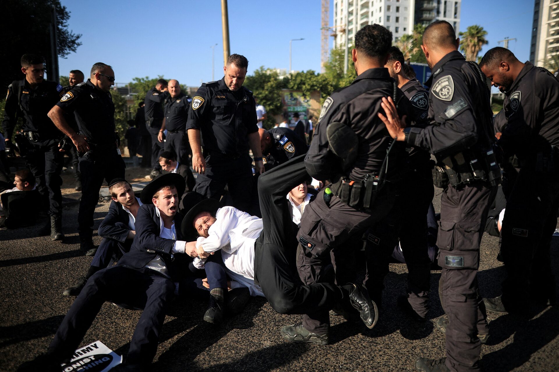 أفراد من الشرطة الإسرائيلية يلقون القبض على أحد اليهود الحريديم خلال احتجاج ضد إلغاء قرار إعفائهم من الخدمة العسكرية في بني براك بإسرائيل يوم 5 حزيران/يونيو 2025 (رويترز)