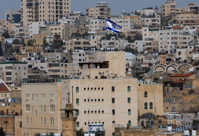 علم إسرائيلي يرفرف فوق مستوطنة إسرائيلية في البلدة القديمة بالخليل في الضفة الغربية المحتلة (رويترز)