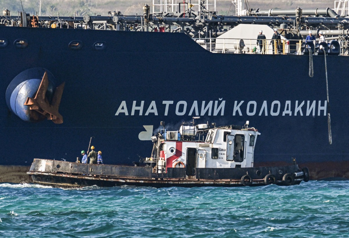 عمال على متن قارب سحب يوجّهون ناقلة النفط الروسية أناتولي كولودكين أثناء وصولها إلى محطة النفط في ميناء ماتانزاس في كوبا، في 31 آذار/مارس 2026 (أ ف ب)