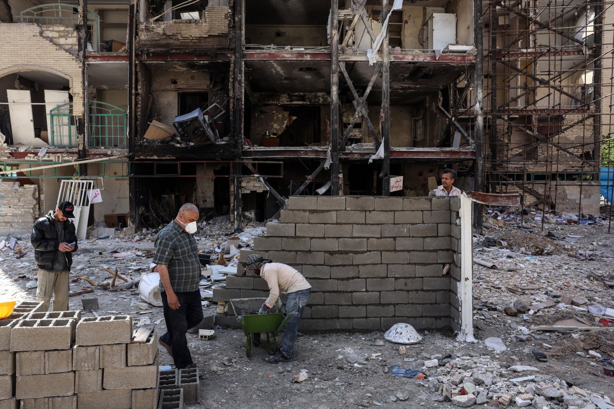 عمال بناء إيرانيون يرمّمون موقعاً تعرّض لغارات أميركية إسرائيلية في طهران (أ ف ب)