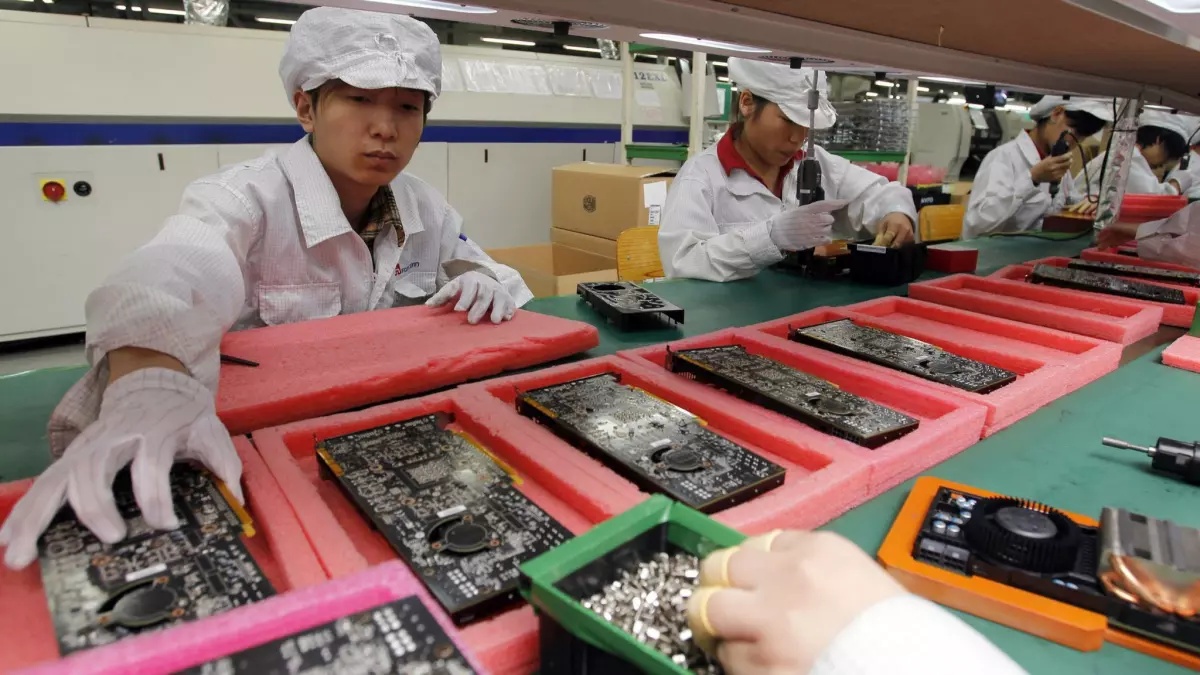 عمال فوكسكون يجمعون أجهزة آيفون في شنتشن جنوب الصين. (اسوشيتد برس)