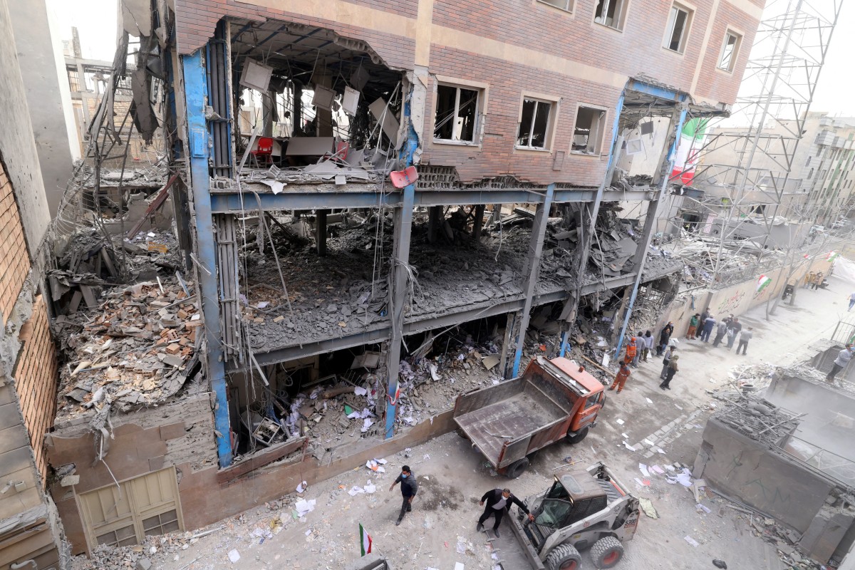 عمال إيرانيون يزيلون الأنقاض من مبنى متضرر، في أعقاب غارة عسكرية على العاصمة الإيرانية طهران في 15 آذار/مارس 2026 (أ ف ب)
