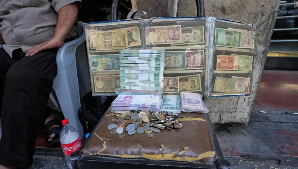 أوراق نقدية إيرانية حالية وأخرى تعود إلى ما قبل الثورة، يعرضها صرّاف في ساحة الفردوسي وسط طهران، 24 آب/أغسطس 2026. (أ ب)