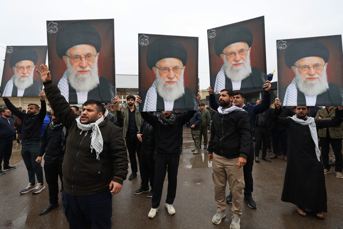 أشخاص يحملون صور المرشد الأعلى الإيراني الراحل علي خامنئي أثناء مشاركتهم في تشييع قائد عمليات الحشد الشعبي في الأنبار سعد دواي في بغداد في 24 آذار/مارس 2026 (أ ف ب)