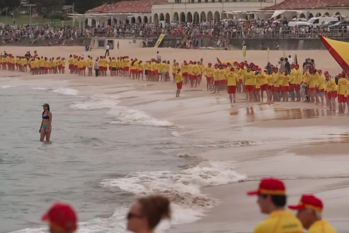 رجال الإنقاذ الأستراليين يقفون في صمت على شاطئ بوندي ‏في سيدني تكريما لقتلى إطلاق النار (أ ف ب)‏